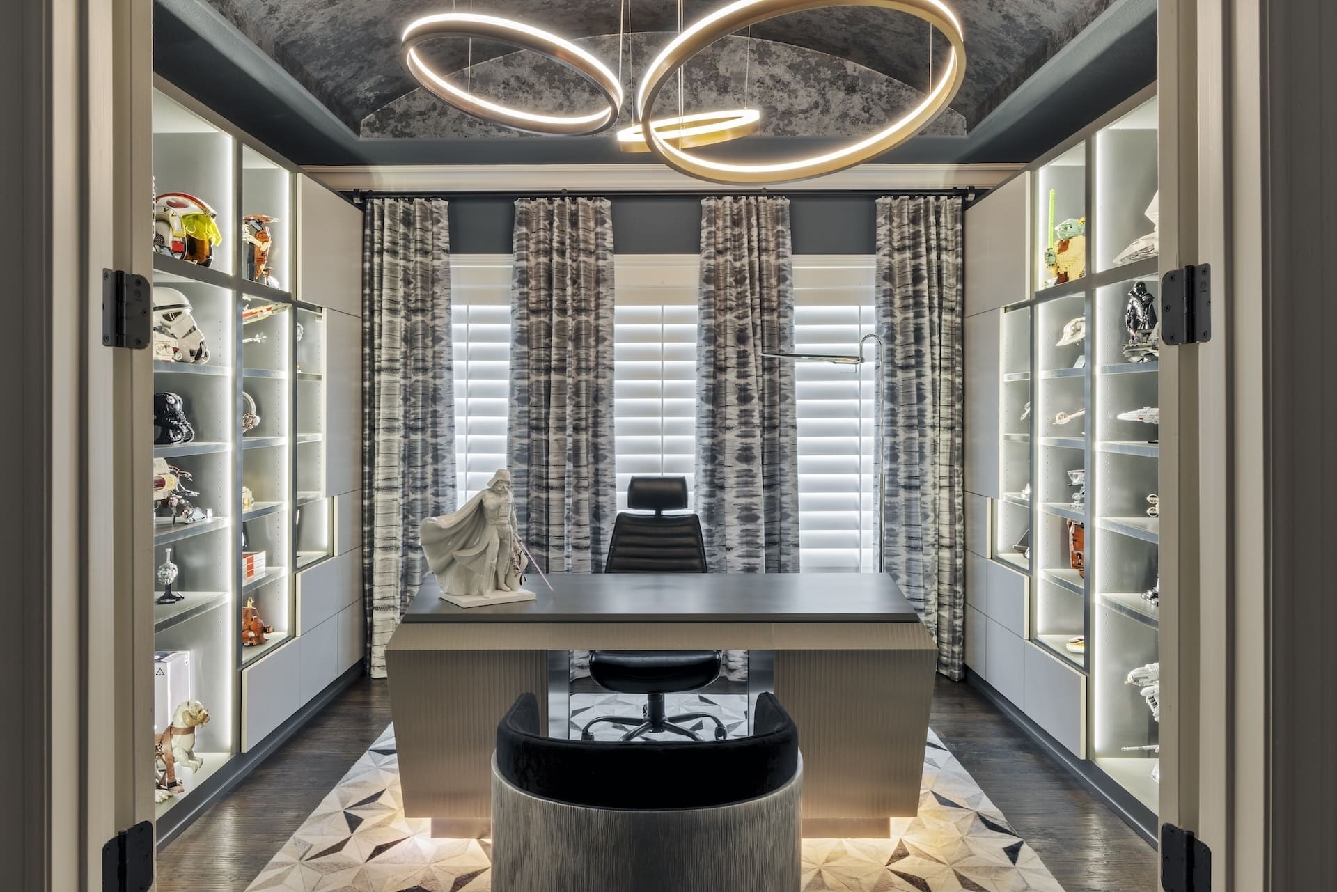 Close-up of custom Millennium Falcon drawer hardware on grey cabinetry paired with a geometric cowhide rug in a luxury Frisco home office.