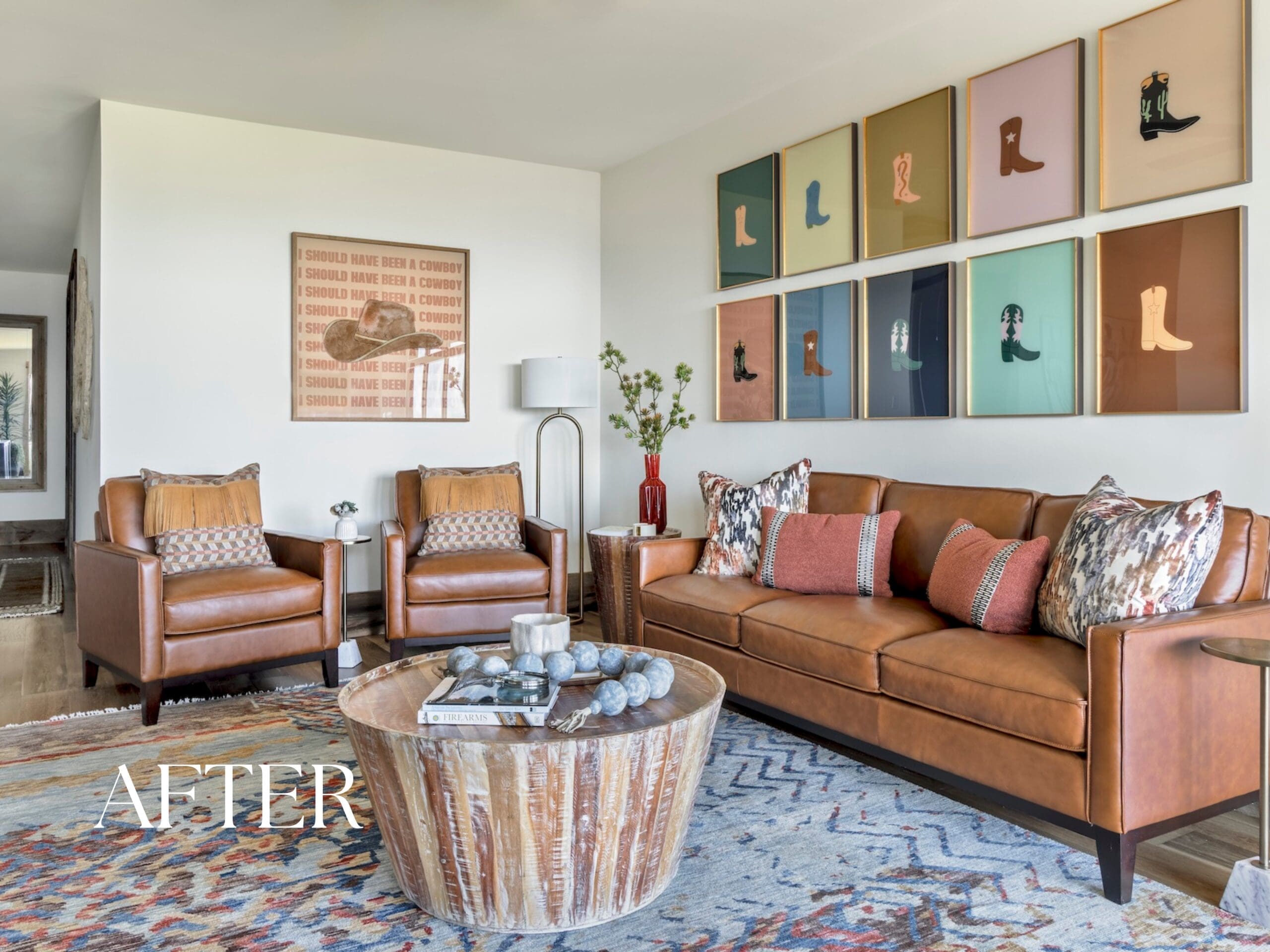 Luxury Ozark mountain retreat living room designed by Baker Design Group, featuring a warm brown leather sofa, a vibrant gallery wall of art, and organic modern decor.