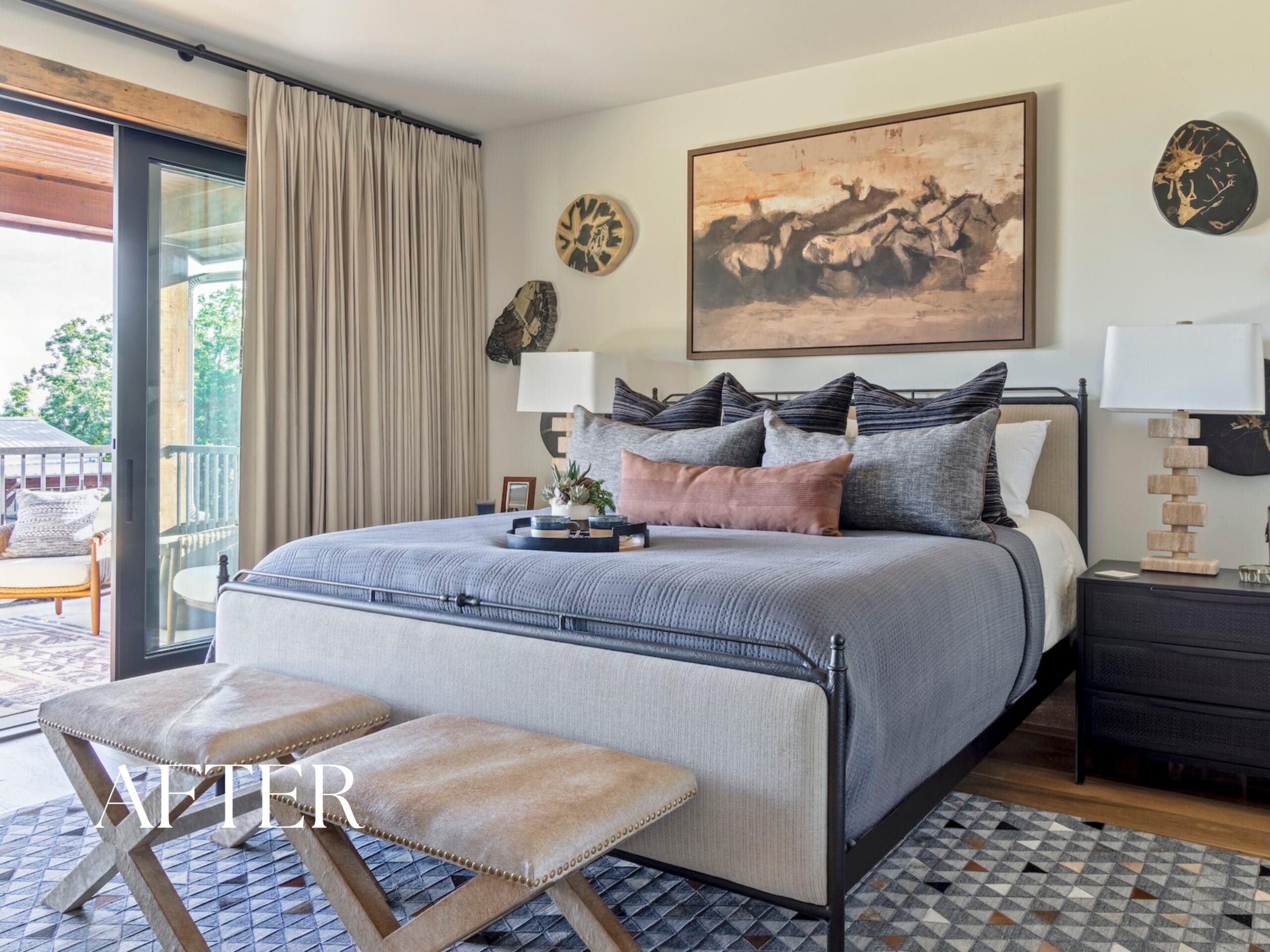 High-end Ozark vacation home guest bedroom by Baker Design Group, showcasing a custom blue upholstered bed, luxury washable bedding, and framed nature-inspired landscape artwork.