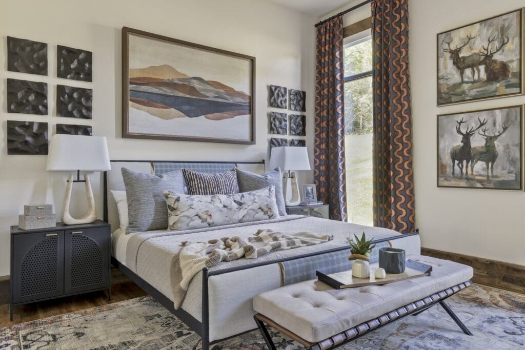 Luxurious bedroom suite in an Ozark mountain retreat featuring a cozy bed, an inviting seating area, large windows with scenic views, and elegant interior design."