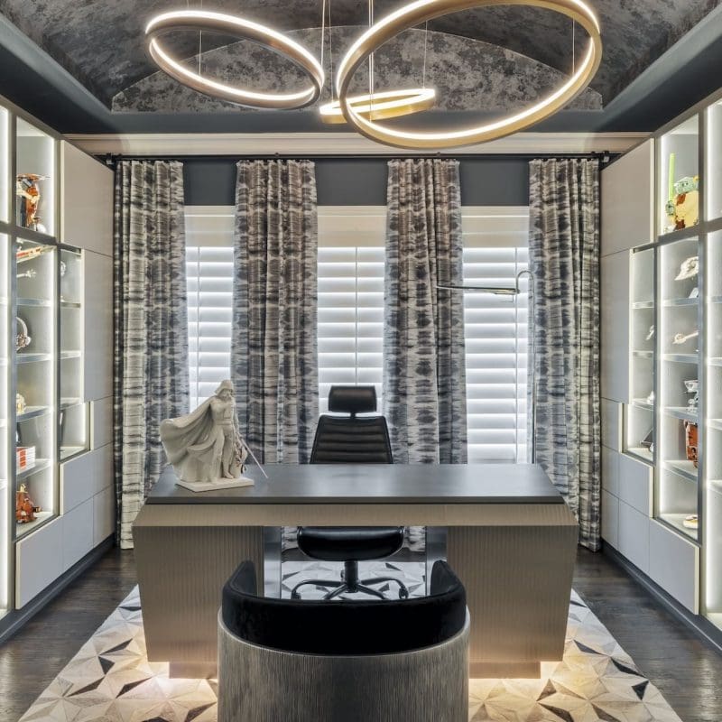 Close-up of custom Millennium Falcon drawer hardware on grey cabinetry paired with a geometric cowhide rug in a luxury Frisco home office.