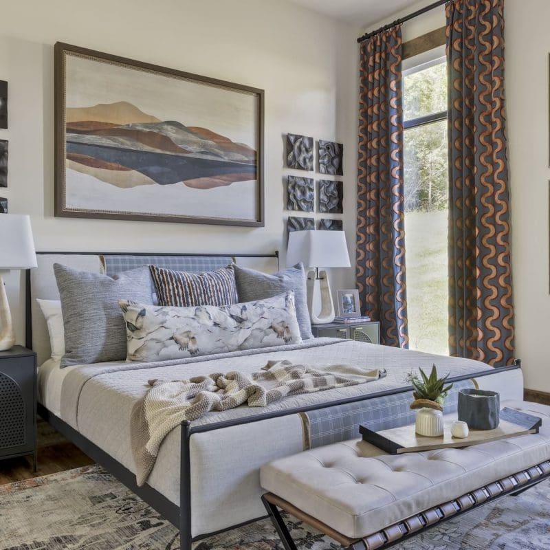Luxurious bedroom suite in an Ozark mountain retreat featuring a cozy bed, an inviting seating area, large windows with scenic views, and elegant interior design."